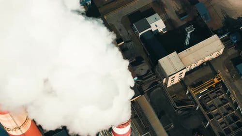 Heavy smoke billows from coal power plant stacks, contributing to air pollution