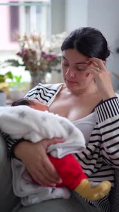 Woman Nursing Baby Indoors by Window