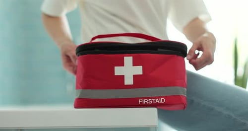 Woman Opening First Aid Kit Picking Up Pills