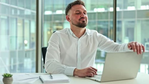 Businessman Finishing Work on Laptop and Relaxing in Modern Office
