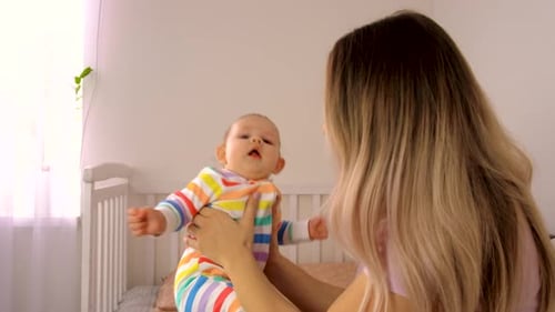 Mother Holding Baby in Bright Room