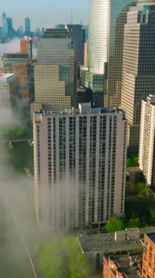Manhattan Island skyscrapers reflecting morning sun. Flying over the East river waterfront covered