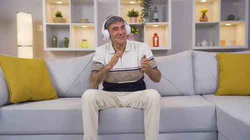 Man With Headphones Dances on Living Room Couch