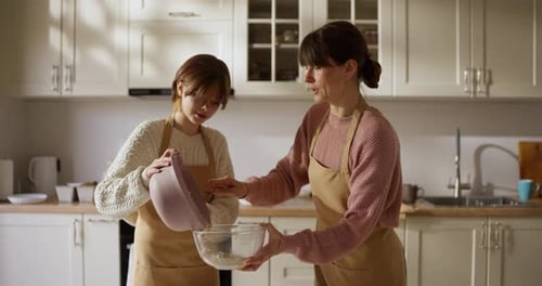 Mother and Daughter Baking Together in a Kitchen