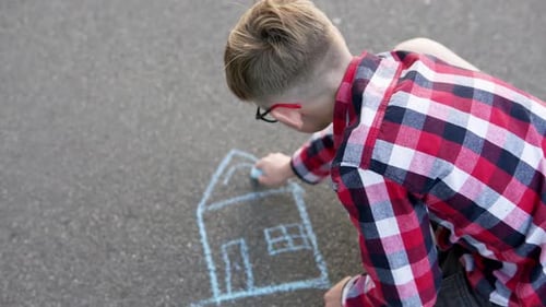 Child draws dream house on asphalt with chalk. Real estate purchase concept.
