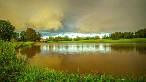 Timelapse of blue sky, clouds on motion, sun rays, and rainbow reflection at lake