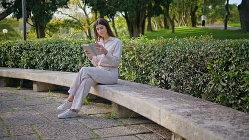 Focused Girl Reading Book in Sunlit Park Conveying Peace Woman Enjoying Leisure