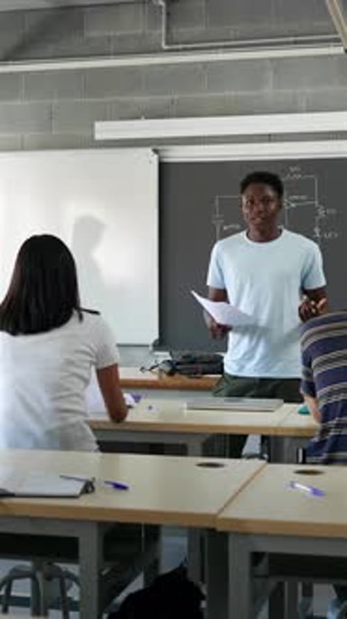 African American Male College Student Presenting a Project Reading Essay to Classmates and Teacher