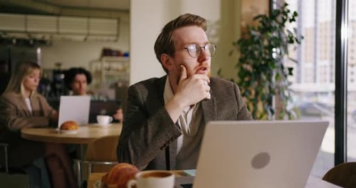 Owner Of Bankrupt Company Sitting Alone In Cafe Looking At Laptop And Thinking About New Startup