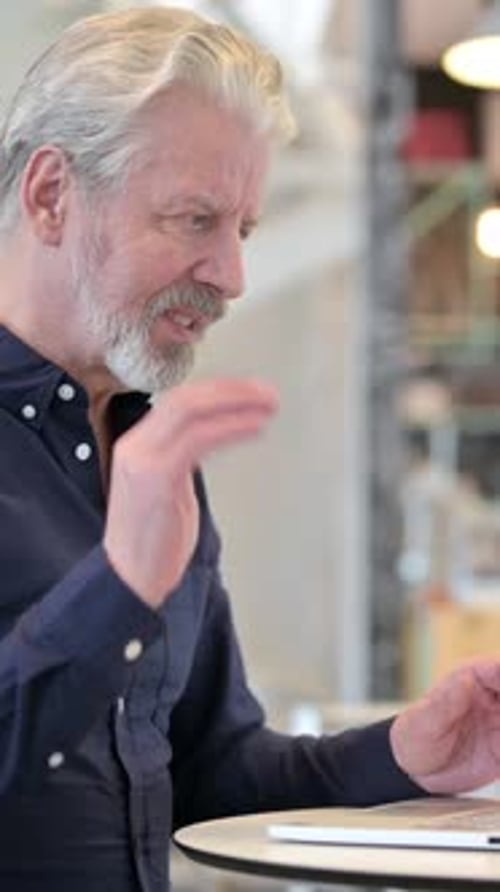 Video Chat on Laptop by Old Man in Cafe, vertical video