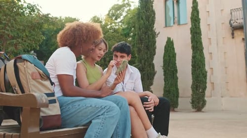 Side view of friends having fun sharing media with an cellphone