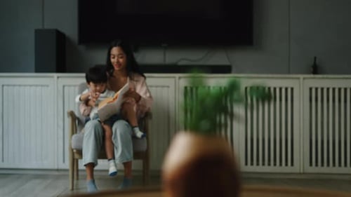 Woman and Child Read a Book on a Chair