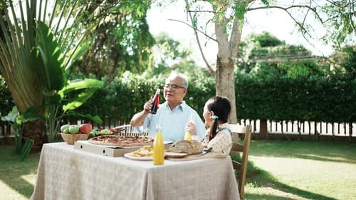 Grandfather and Child Enjoying Outdoor Meal Together