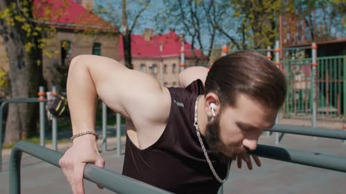 Athletic Lebanese Man in Sportswear Practicing Dips on Parallel Bars Training Triceps on Playground