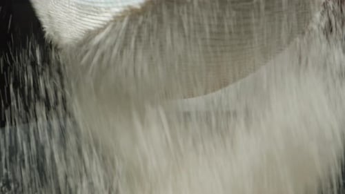 sift flour through a sieve, close-up view from below.