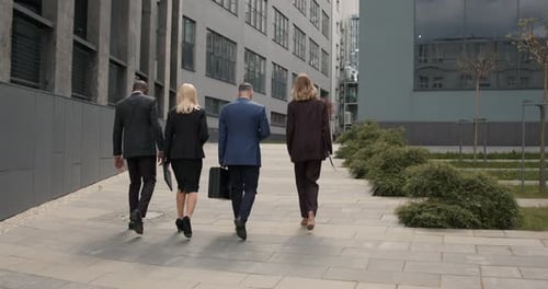 Business People Walking Outdoors Near Office Building