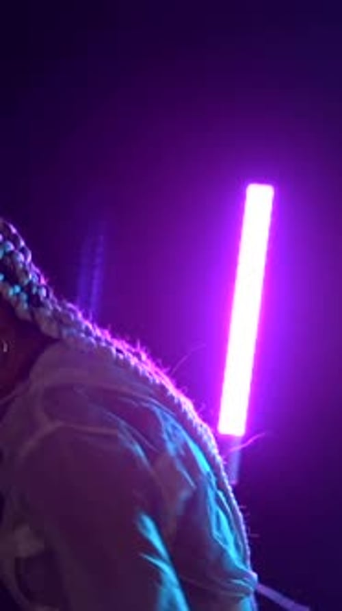 Trap or rap dancer dancing with neon lights against it, dancing in a disco with blue and red light l