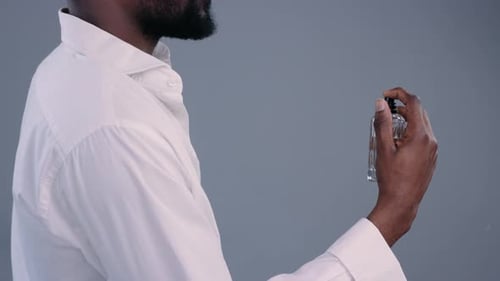 Adult Male Sprays Cologne in Studio Setting