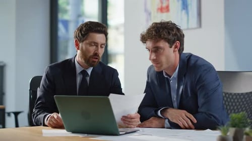 Businessmen Collaborate on Project in Modern Office