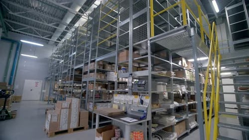 Une grande pièce grise vide avec des colis entreposés qui seront livrés par des coursiers