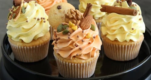 Delicious cupcakes with festive frosting and toppings rotating