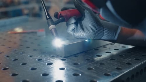 Worker Welding Metal in Industrial Setting