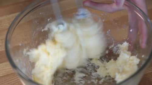 mezclar mantequilla y otros ingredientes en un tazón con una batidora de mano en casa