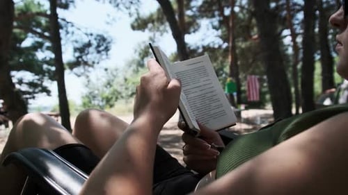 Woman Reads a Book Outdoors on Relaxing Day