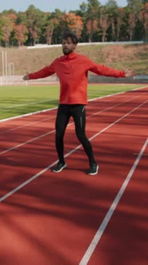 Junger männlicher Athlet führt Cardio-Trainingsübungen durch, um sich vor dem Laufen aufzuwärmen. Gesund