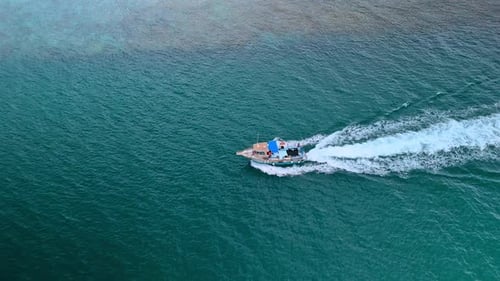 Aerial View of Boat Speeding Across Ocean