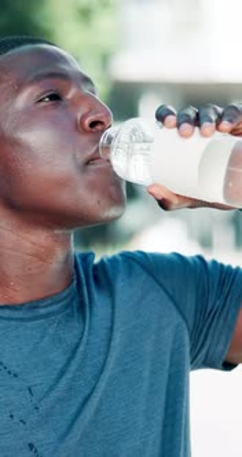Outdoor, black man and fitness with water for drinking, hydration and liquid beverage for workout