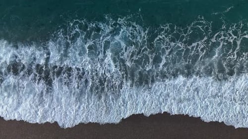 Aerial Drone Shot of Ocean Waves Crashing on a Sandy Beach