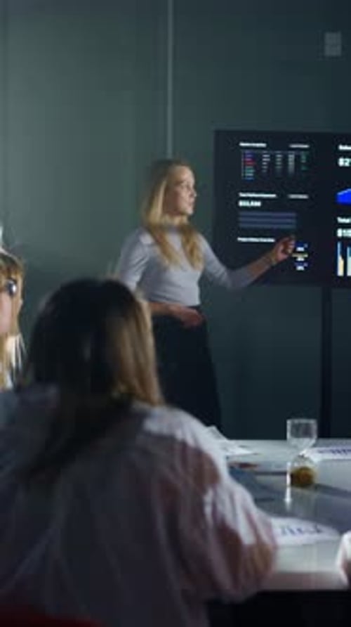 Businesswoman Presents Sales Data to Colleagues in Boardroom