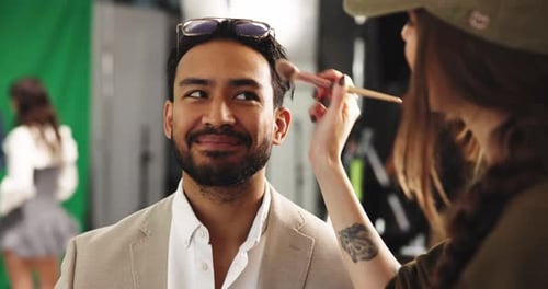 Makeup, laugh and beautician with man in studio with facial touchup for photoshoot or filming