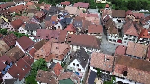Aerial Shot Over Rooftops Of Half Timbered Houses In Village Of Bergheim In France. Slow Pan Right
