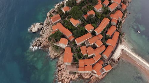 AERIAL - Sveti Stefan island luxury resort and tombolo, Montenegro, top down rising