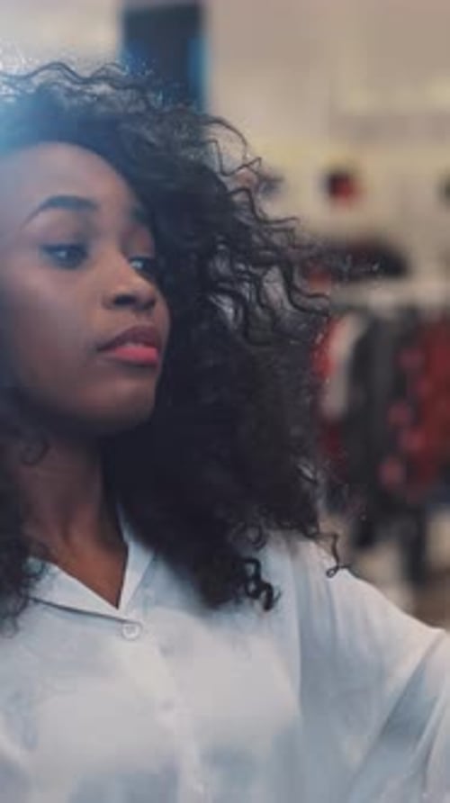 Une femme confiante avec de beaux cheveux bouclés sourit joyeusement dans un cadre lumineux et vibrant