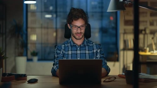Portrait du jeune entrepreneur créatif beau et prospère travaillant à son bureau à l'aide d'un ordinateur portable