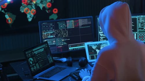Person Coding at Computer Desk in Dark Room
