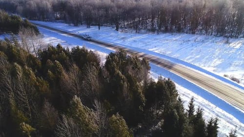 Boom Lift Truck Drives Across Picturesque Forest in Winter