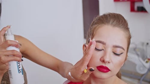 Glückliche vietnamesische Stylistin und europäische Maskenbildnerin arbeiten daran, ein Bild für