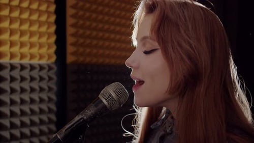 Cute Young Woman Recording a Song in the Studio Singing in the Mic