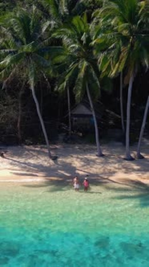 Two Individuals Lounging on a Sandy Beach with Palm Trees Koh Wai Island Thailand