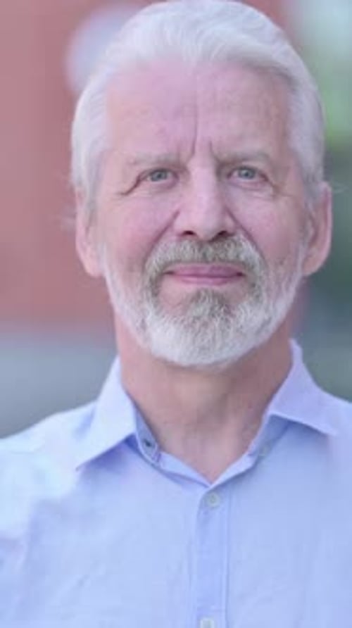 Senior Man Smiles and Speaks in Vertical Format