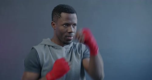 Young Adult Boxing in Gray Hoodie, Red Wraps