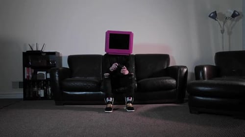 Person with TV Head Sits on Couch and Plays