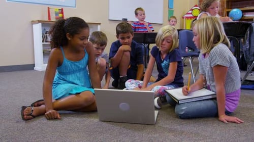 Elementary School Students Look at Laptop Computer Together 6-7