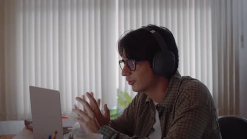 Man on Video Call with Laptop and Headphones Indoors