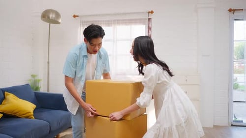 Couple Unpacking Cardboard Boxes in New Home