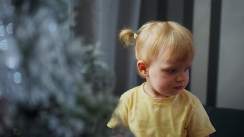 Adorable Child Decorating Christmas Tree with Ornament